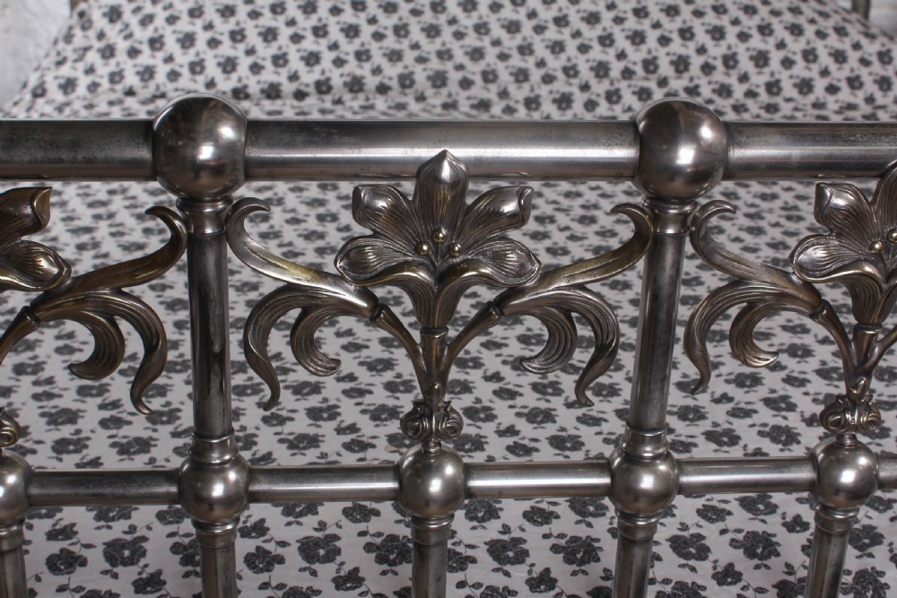 A nickel-plated super king size bedstead featuring Art Nouveau floral metalwork detailing on the arched headboard and footboard. View III