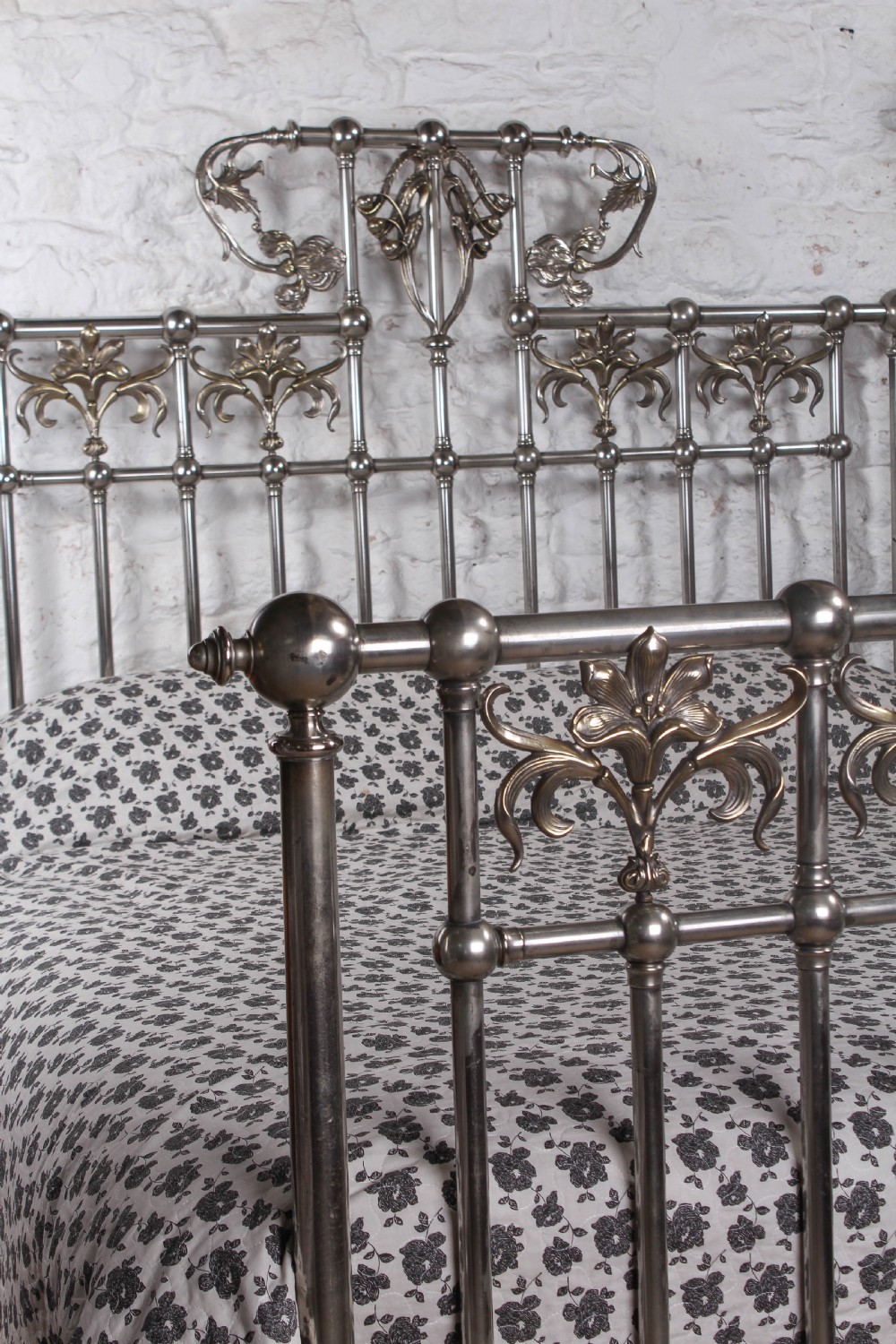 A nickel-plated super king size bedstead featuring Art Nouveau floral metalwork detailing on the arched headboard and footboard. View XI