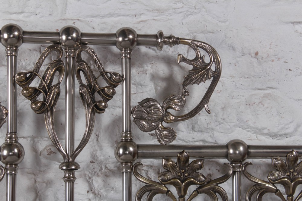 A nickel-plated super king size bedstead featuring Art Nouveau floral metalwork detailing on the arched headboard and footboard. View XII