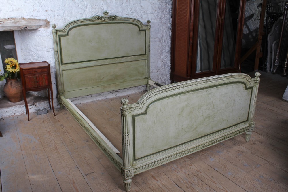A French Louis XVI style king size bedstead in distressed sage green paint with carved fluted posts and decorative molding. View IX