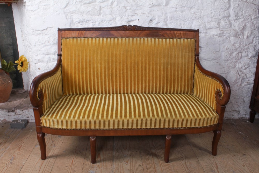 A French Directoire two-seater sofa featuring a polished fruitwood frame and yellow striped velvet upholstery secured with brass studding. View II