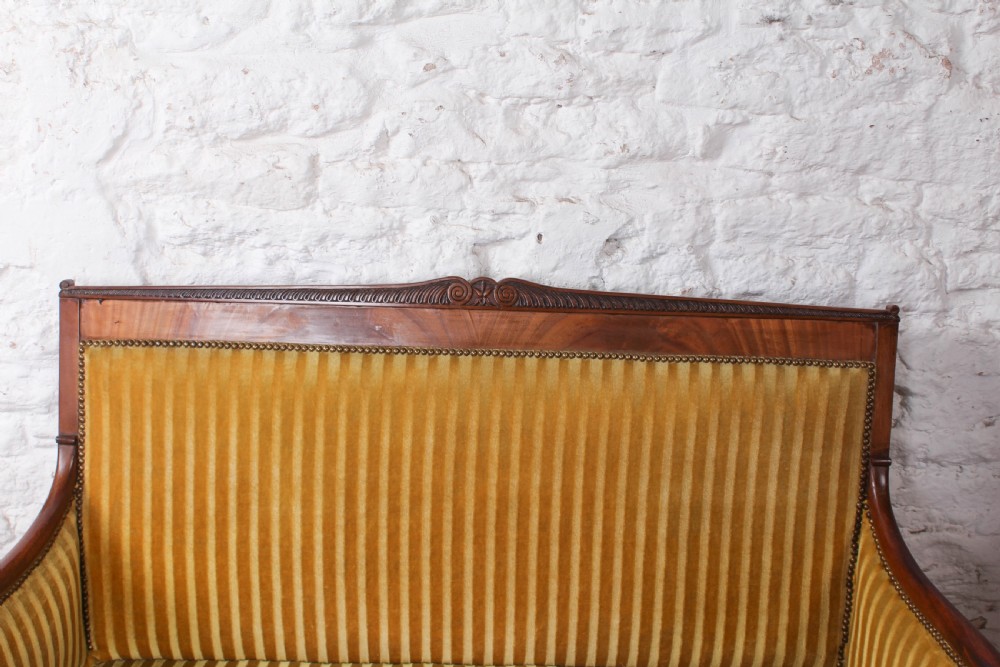 A French Directoire two-seater sofa featuring a polished fruitwood frame and yellow striped velvet upholstery secured with brass studding. View III