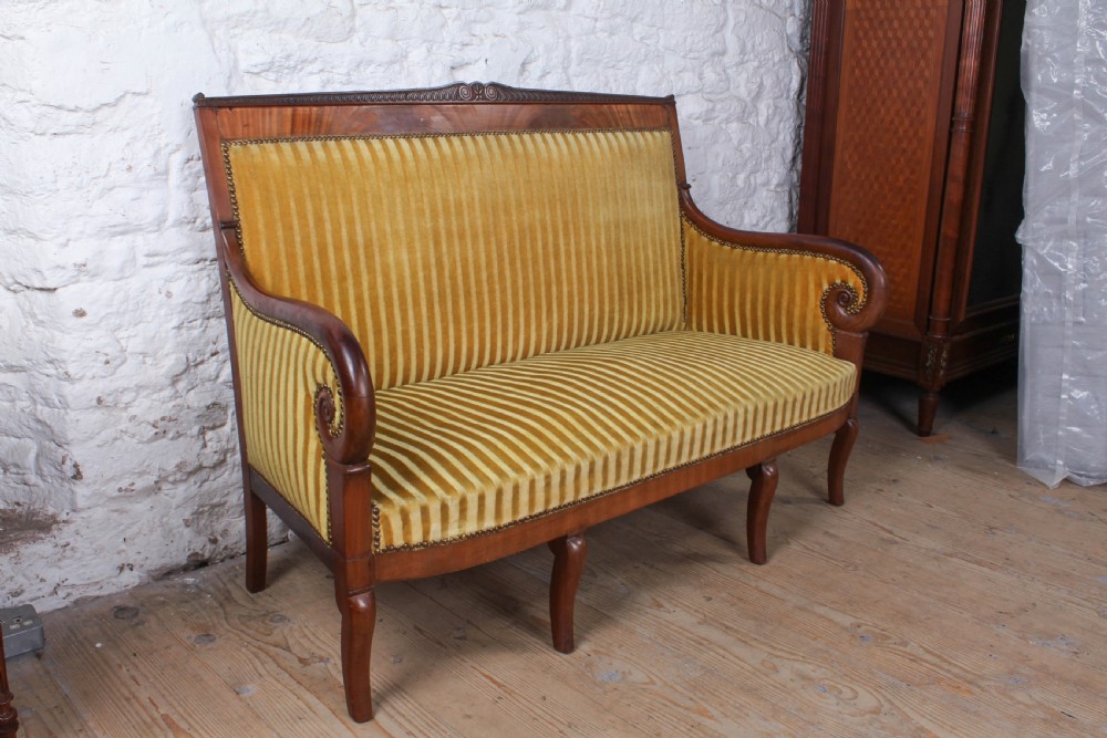 A French Directoire two-seater sofa featuring a polished fruitwood frame and yellow striped velvet upholstery secured with brass studding. View IV