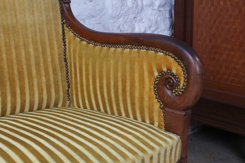 A French Directoire two-seater sofa featuring a polished fruitwood frame and yellow striped velvet upholstery secured with brass studding. View VI