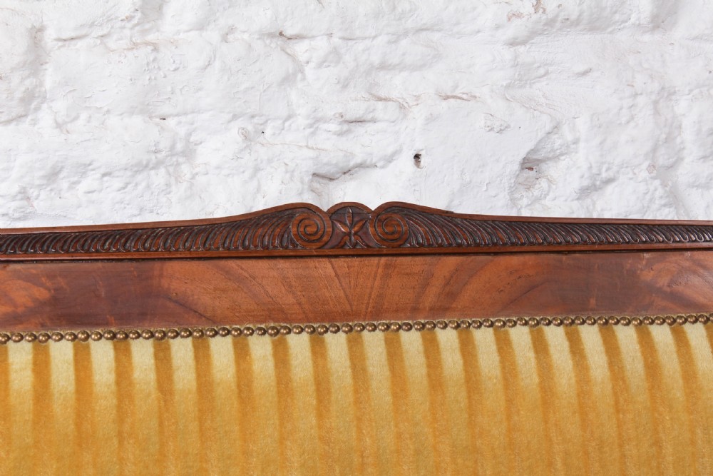 A French Directoire two-seater sofa featuring a polished fruitwood frame and yellow striped velvet upholstery secured with brass studding. View VII