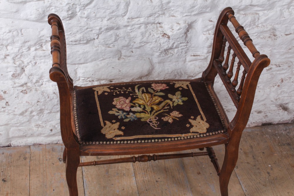 A French wooden stool featuring raised spindled side galleries, turned stretchers, and a dark floral tapestry seat fastened with brass studs. View III
