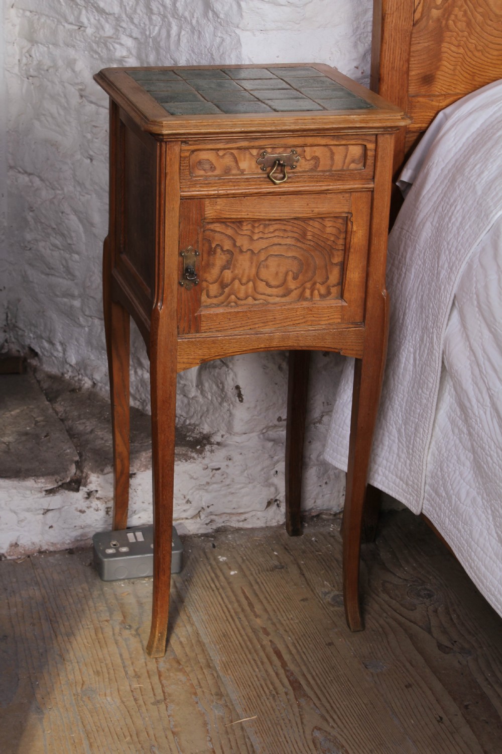 An Art Nouveau wooden bedroom suite featuring a curved double bedstead, matching dressing table with mirror, nightstand, and leather-upholstered side chairs. View VII