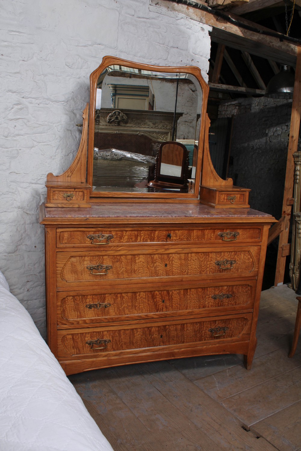 An Art Nouveau wooden bedroom suite featuring a curved double bedstead, matching dressing table with mirror, nightstand, and leather-upholstered side chairs. View XI