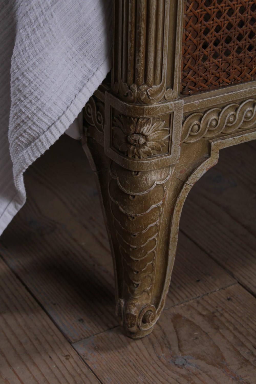 A French Louis XVI style super king bedstead featuring woven rattan cane panels, carved floral swags, and matching caned side chairs in a painted distressed finish. View III