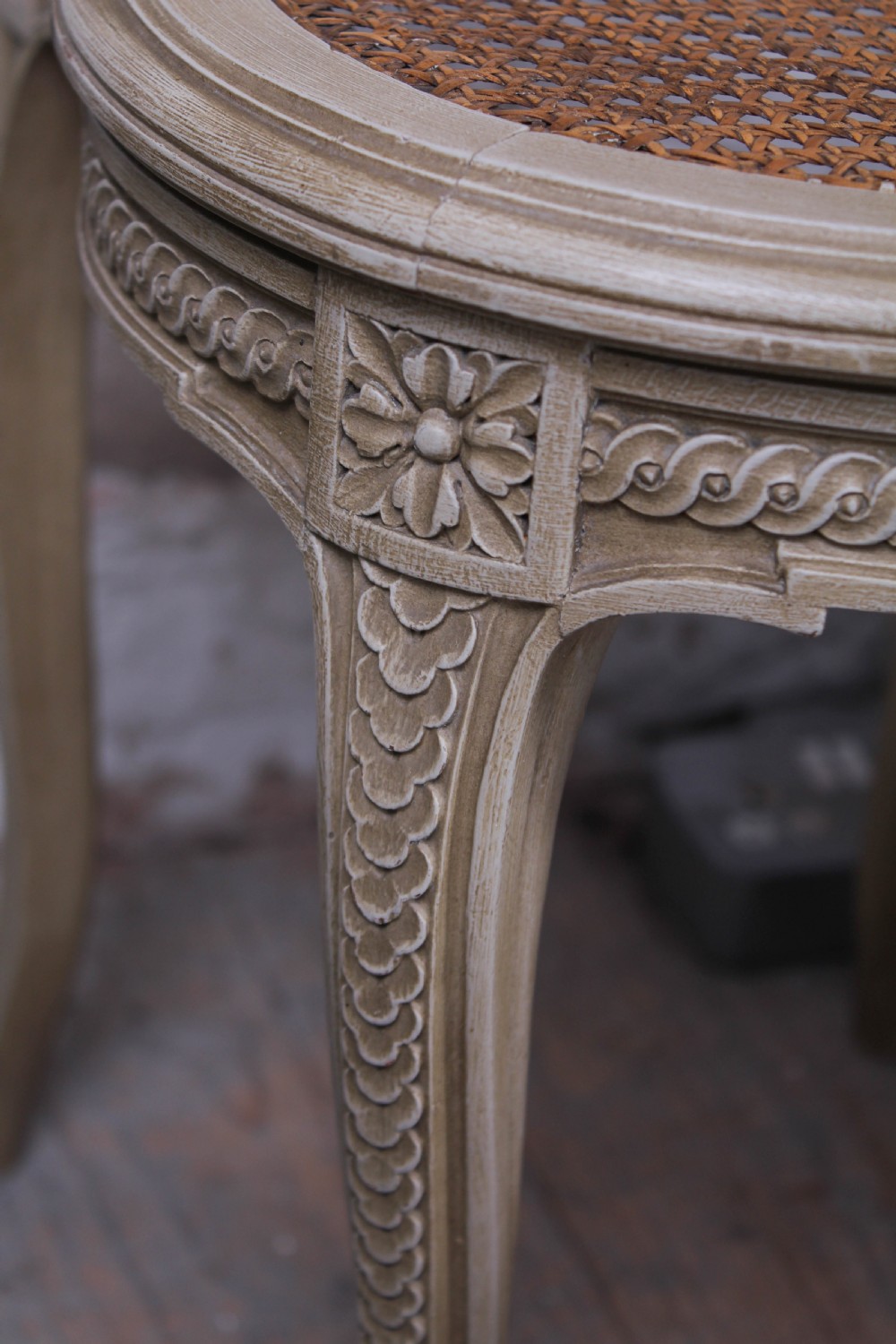 A French Louis XVI style super king bedstead featuring woven rattan cane panels, carved floral swags, and matching caned side chairs in a painted distressed finish. View XIV