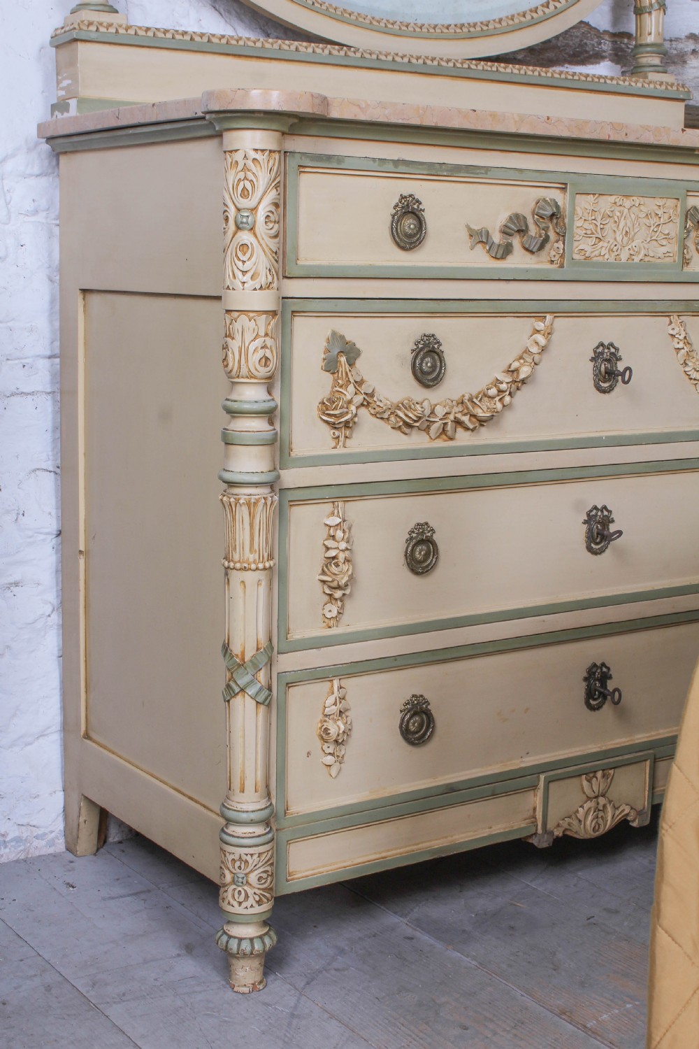 A cream and green painted super king size bedroom set featuring a detailed caned headboard, carved garlands, two matching bedside tables, and a chest of drawers with an oval mirror. View XI