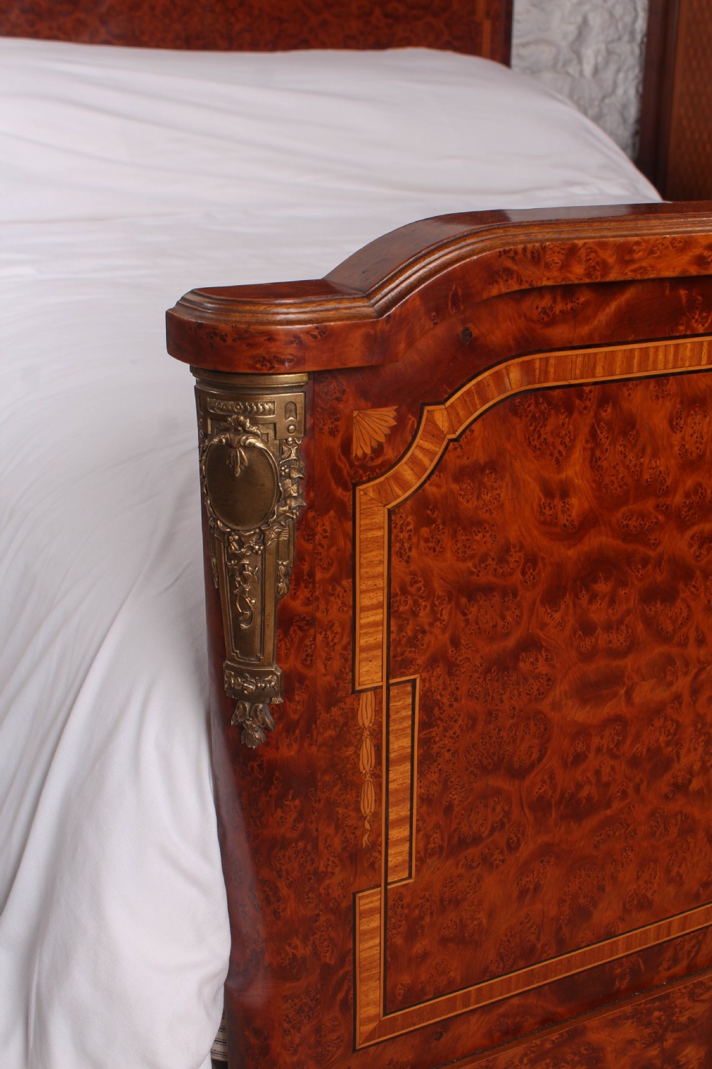A French style kingsize bed frame in warm brown burr mahogany with fruitwood inlay borders and gilt metal corner mounts. View IV