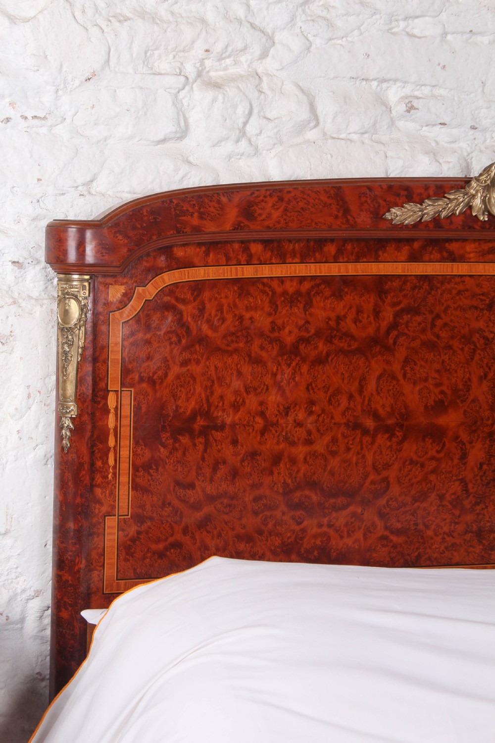 A French style kingsize bed frame in warm brown burr mahogany with fruitwood inlay borders and gilt metal corner mounts. View VIII