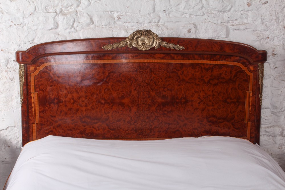 A French style kingsize bed frame in warm brown burr mahogany with fruitwood inlay borders and gilt metal corner mounts. View X