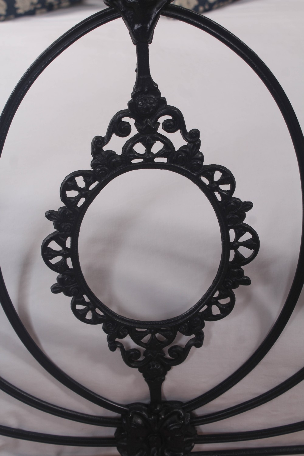 A Victorian black cast and wrought iron double bed frame featuring a three-hoop headboard and footboard with central decorative medallions. View III