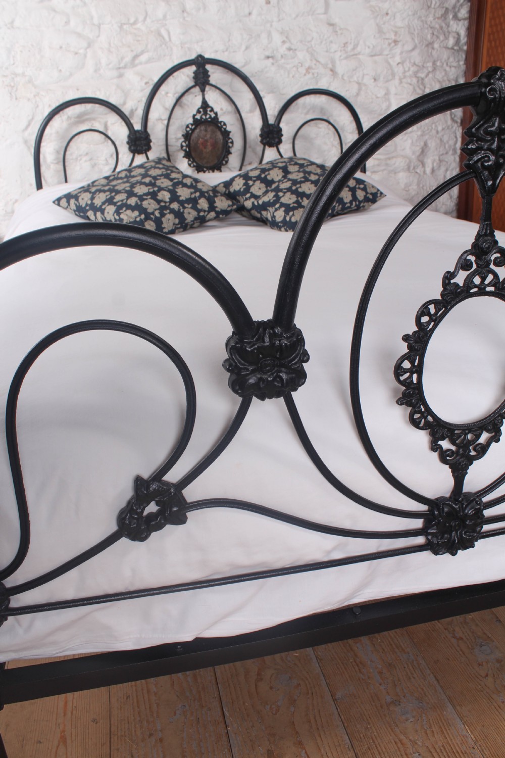 A Victorian black cast and wrought iron double bed frame featuring a three-hoop headboard and footboard with central decorative medallions. View IV