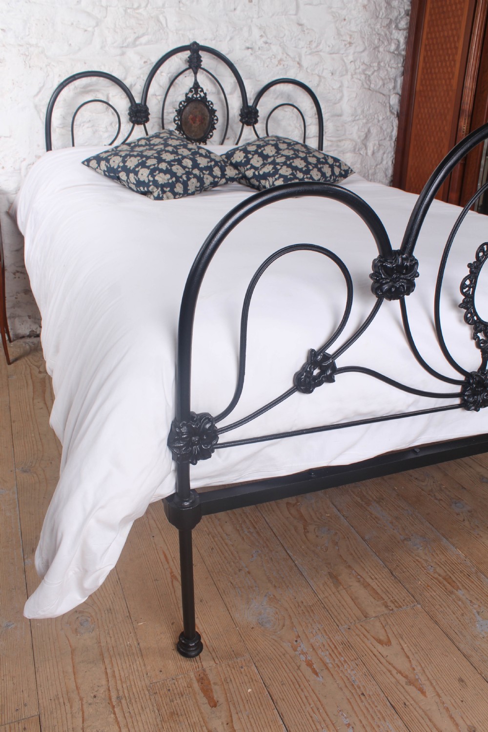 A Victorian black cast and wrought iron double bed frame featuring a three-hoop headboard and footboard with central decorative medallions. View VIII