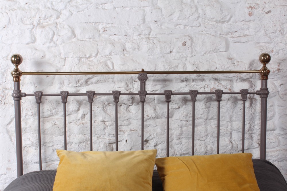 A Victorian double bed frame featuring a grey painted cast iron headboard with vertical spindles, a polished brass top rail, corner finials, and no footboard. View VI