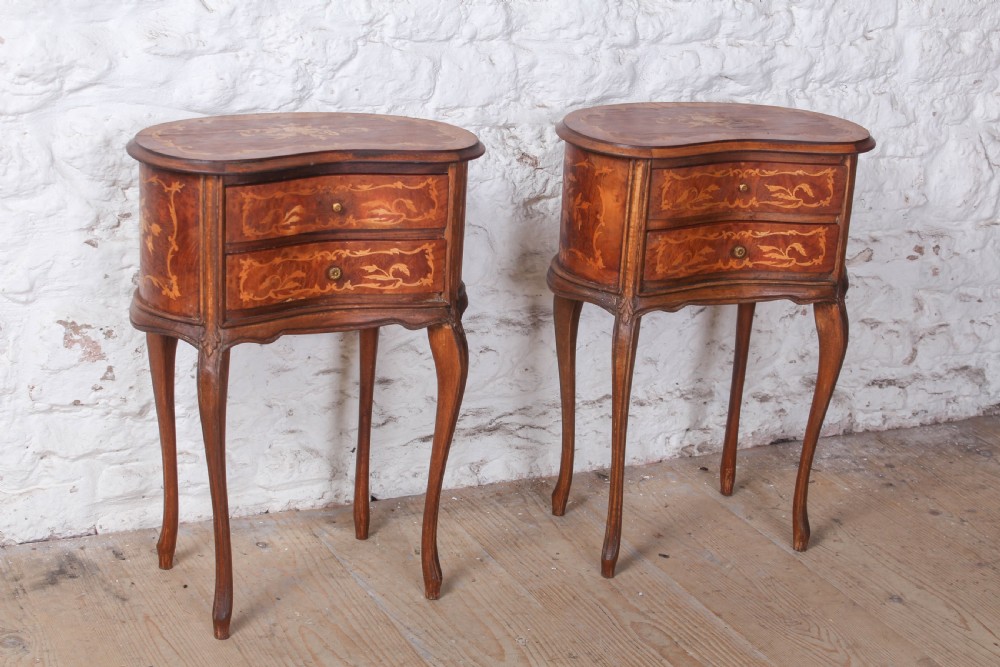 A pair of Louis XV style kidney-shaped bedside tables featuring floral marquetry inlays, two drawers, and slender cabriole legs.