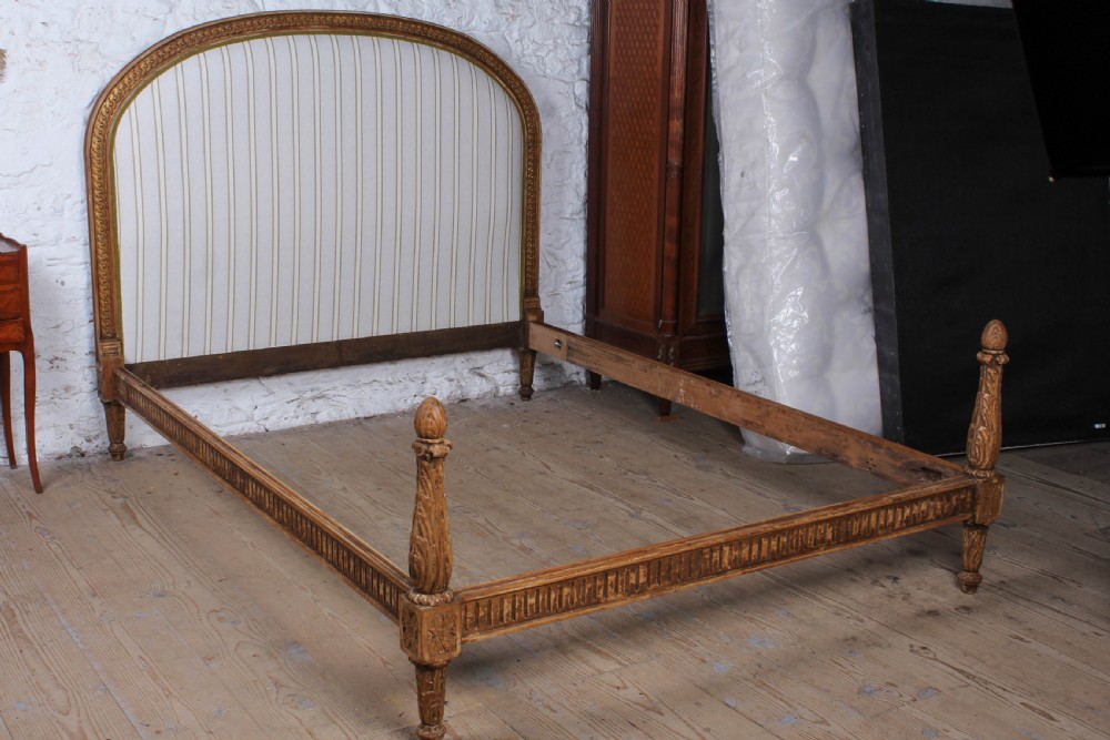 A Louis XVI style king size bed frame featuring a carved timber border, a striped upholstered arched headboard, and low carved corner posts. View II
