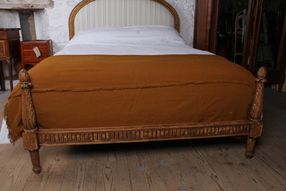 A Louis XVI style king size bed frame featuring a carved timber border, a striped upholstered arched headboard, and low carved corner posts. View V