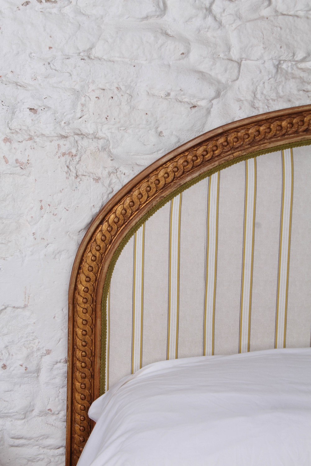 A Louis XVI style king size bed frame featuring a carved timber border, a striped upholstered arched headboard, and low carved corner posts. View VI