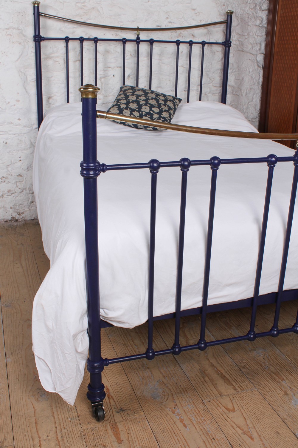 A Victorian metal double bedstead featuring a dark blue painted frame, vertical spindles, dipped brass top rails, and brass corner finials. View III
