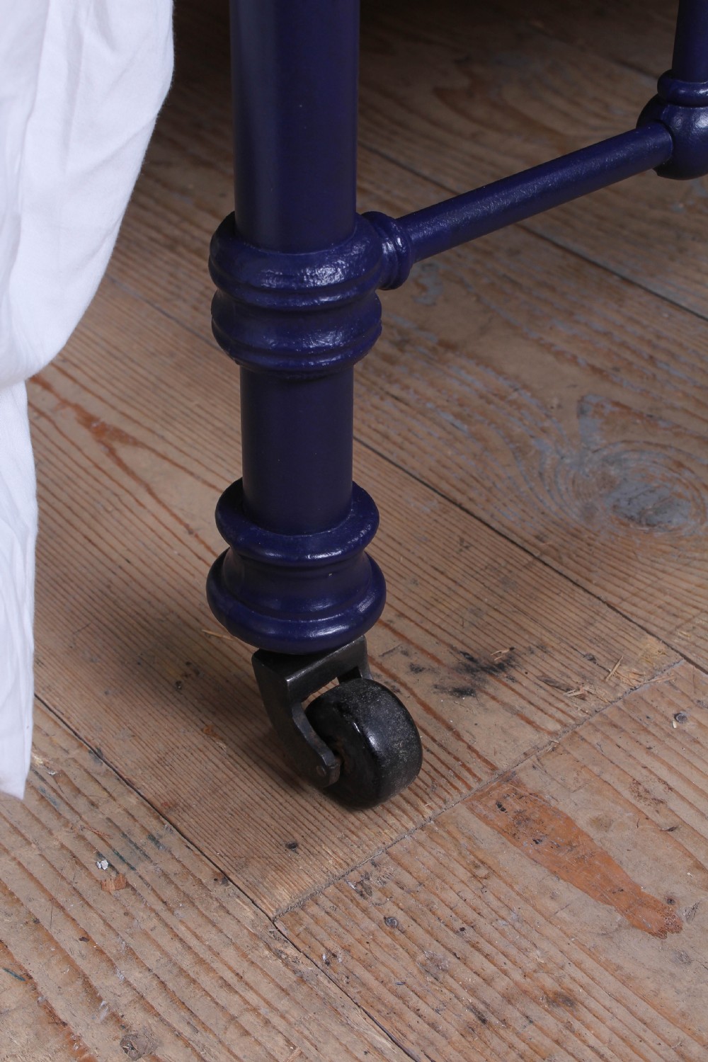 A Victorian metal double bedstead featuring a dark blue painted frame, vertical spindles, dipped brass top rails, and brass corner finials. View IV