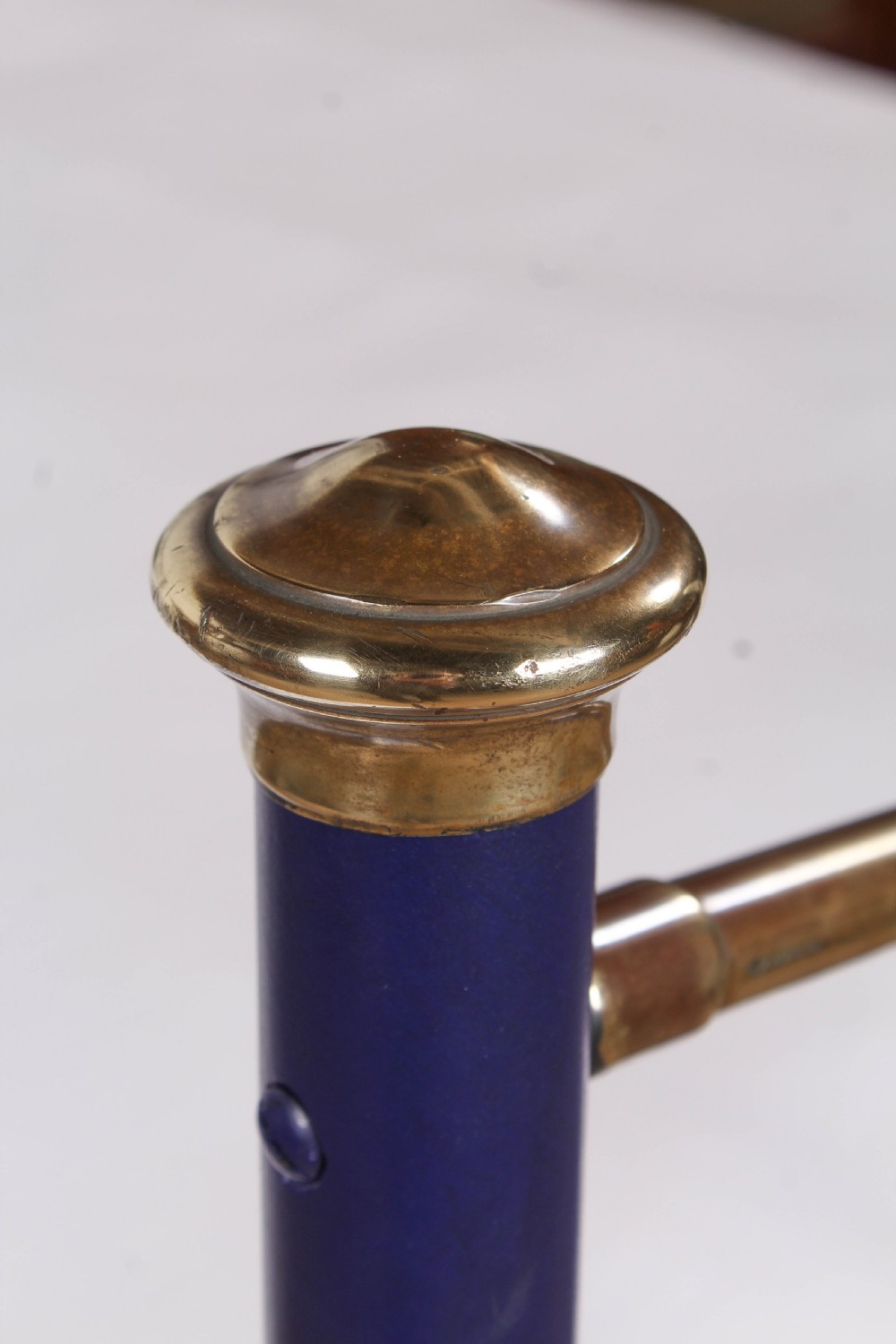 A Victorian metal double bedstead featuring a dark blue painted frame, vertical spindles, dipped brass top rails, and brass corner finials. View VI