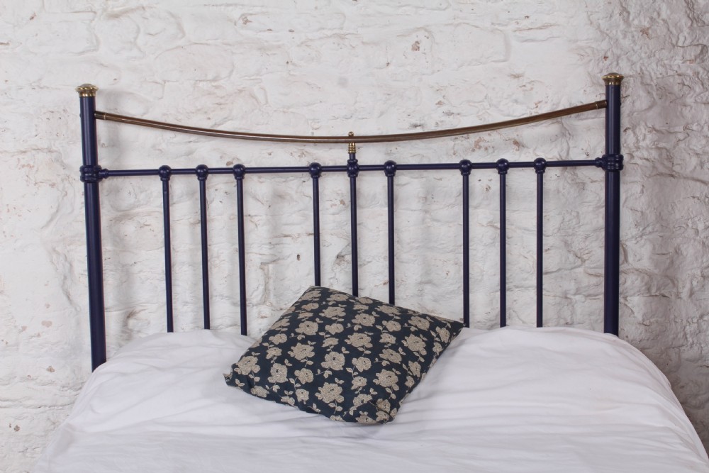 A Victorian metal double bedstead featuring a dark blue painted frame, vertical spindles, dipped brass top rails, and brass corner finials. View VII