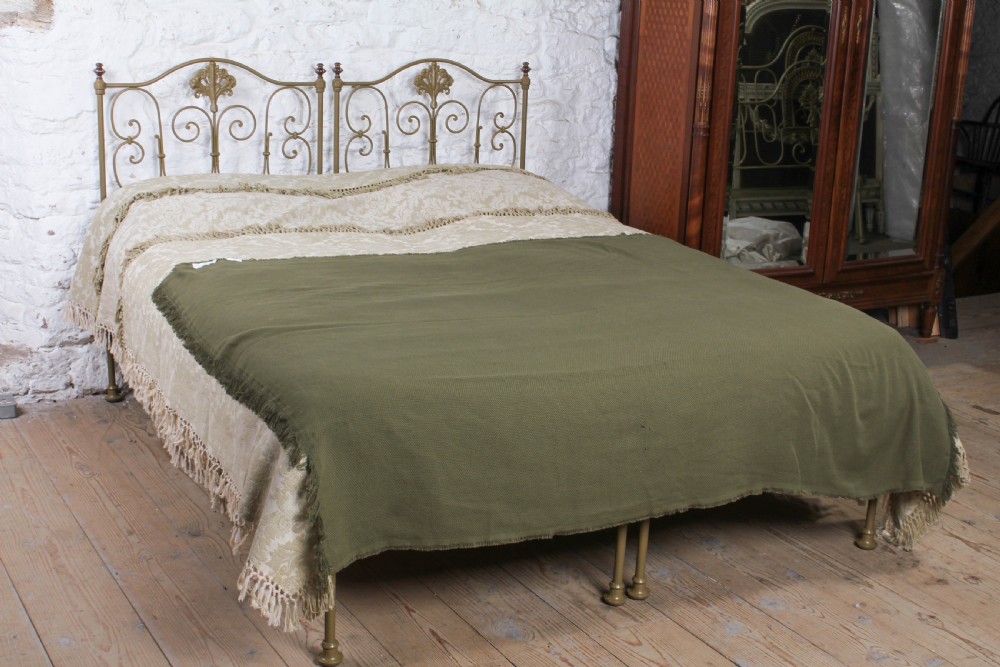 A pair of antique Portuguese small single metal beds featuring arched headboards with ornate metal scrollwork and central shell motifs. View II