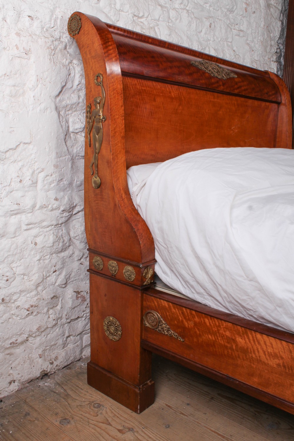 An Empire style mahogany double bedstead featuring rolled headboard profiles, parquetry panelwork, and decorative gilt-bronze mounts. View IV