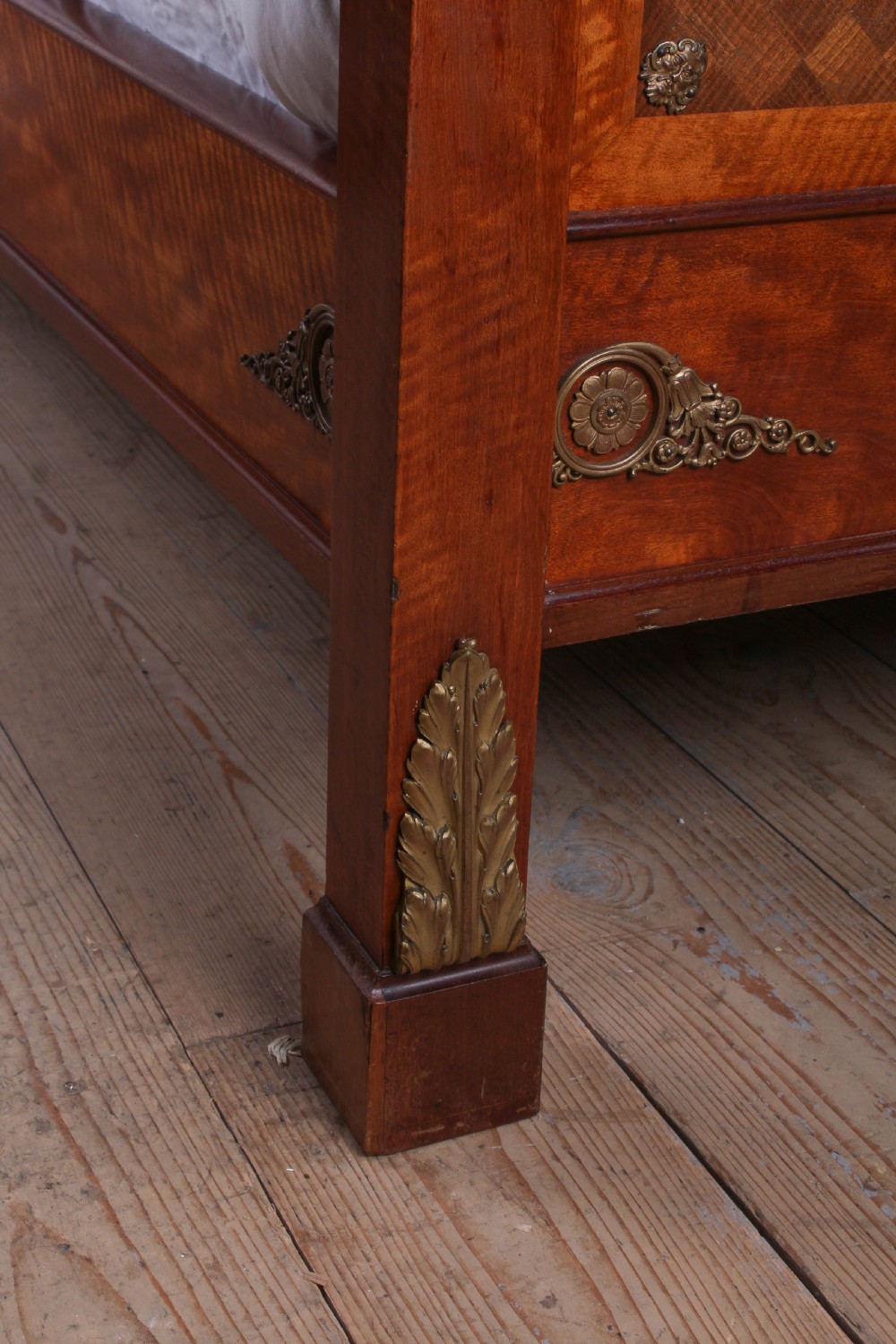 An Empire style mahogany double bedstead featuring rolled headboard profiles, parquetry panelwork, and decorative gilt-bronze mounts. View VIII