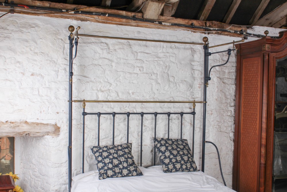 A Victorian black iron and brass king size half tester bed featuring vertical spindles and turned brass finials. View III