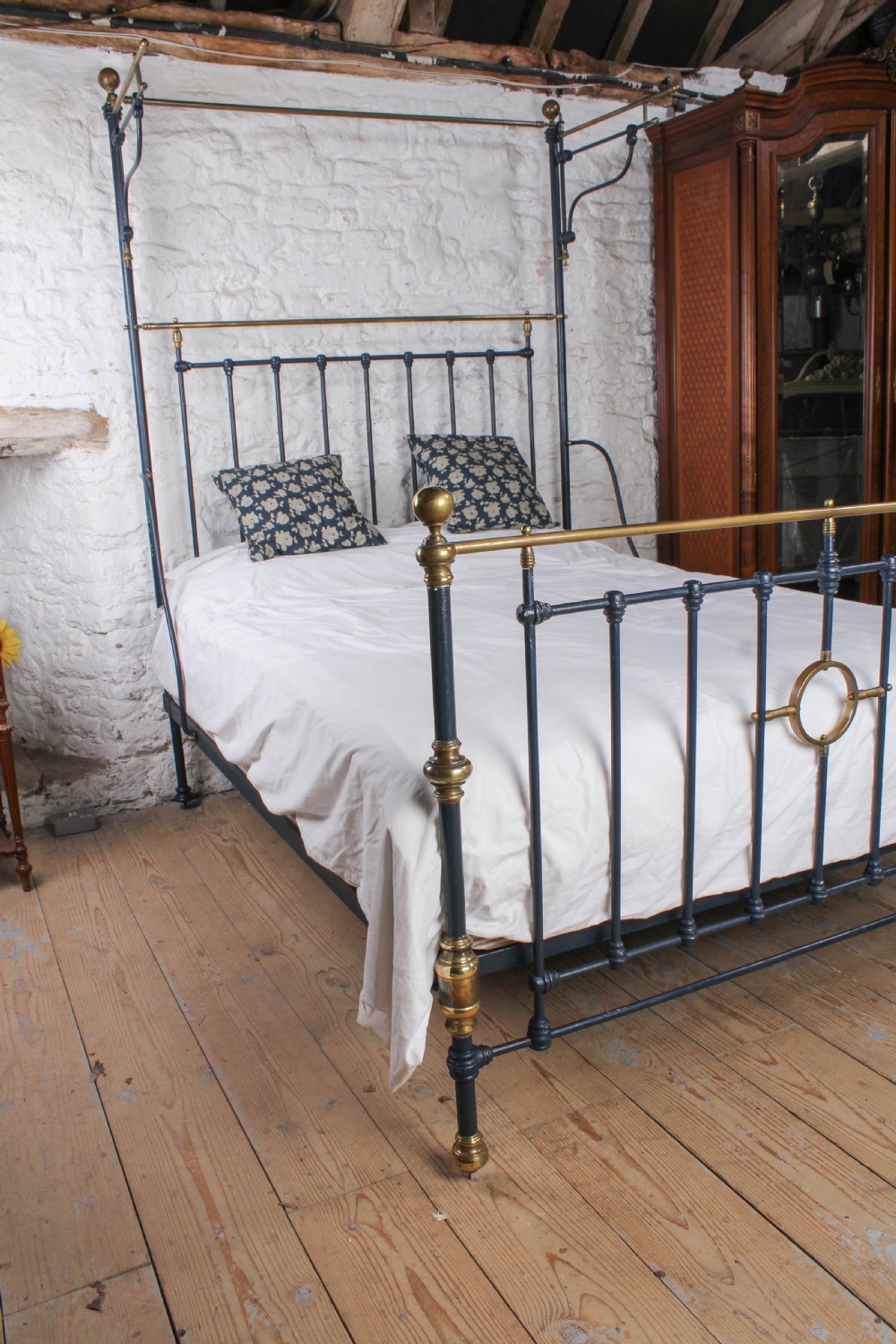 A Victorian black iron and brass king size half tester bed featuring vertical spindles and turned brass finials. View VIII