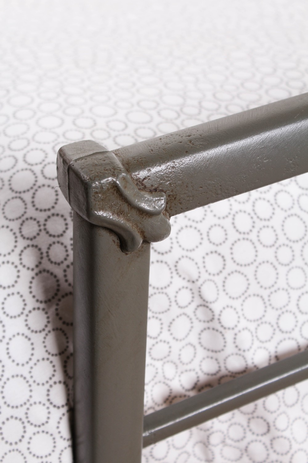 A pair of grey painted Victorian iron single beds with simple arched headboards and footboards. View III