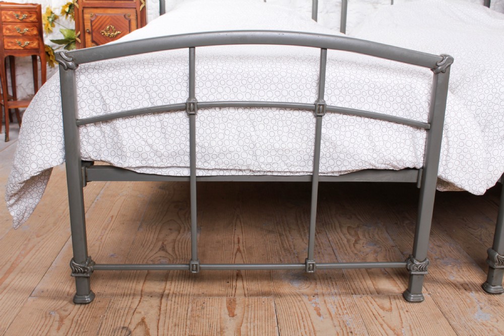 A pair of grey painted Victorian iron single beds with simple arched headboards and footboards. View IV