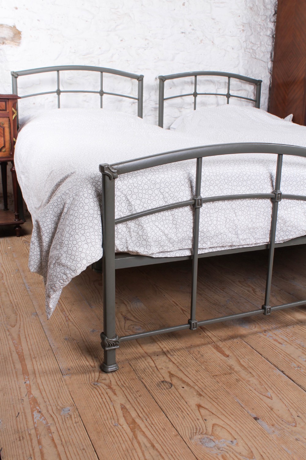 A pair of grey painted Victorian iron single beds with simple arched headboards and footboards. View VI