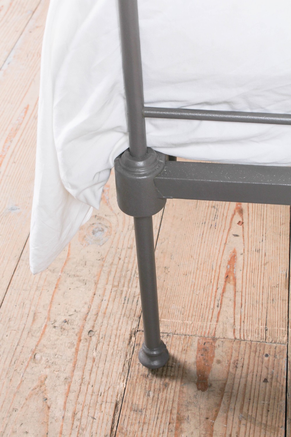 A king size Portuguese iron bed frame painted in a neutral taupe colour, featuring decorative scrollwork and a central shell motif on both the headboard and footboard. View V