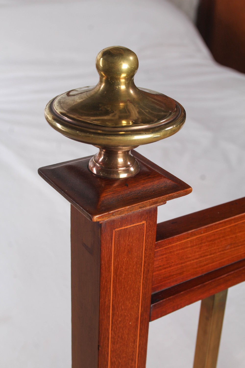 An antique mahogany double bed frame featuring polished brass upright spindles, brass urn finials, and an oval marquetry medallion inlaid on the footboard. View IV