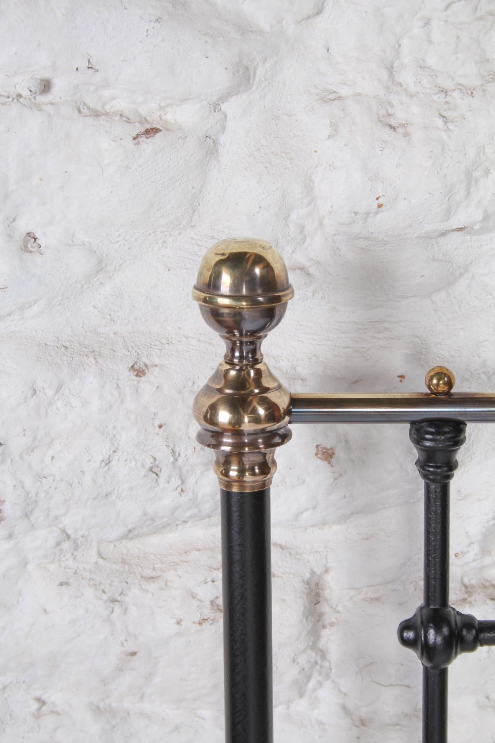 A Victorian single cast iron bedstead with black vertical spindles, brass finials, and white bed linen. View III