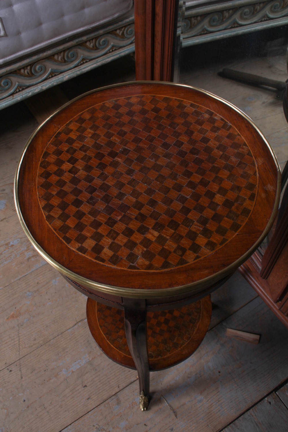 A small, round Louis XV style mahogany side table featuring a brass gallery rim, a single frieze drawer, slender cabriole legs with brass feet, and a lower parquetry shelf. View II
