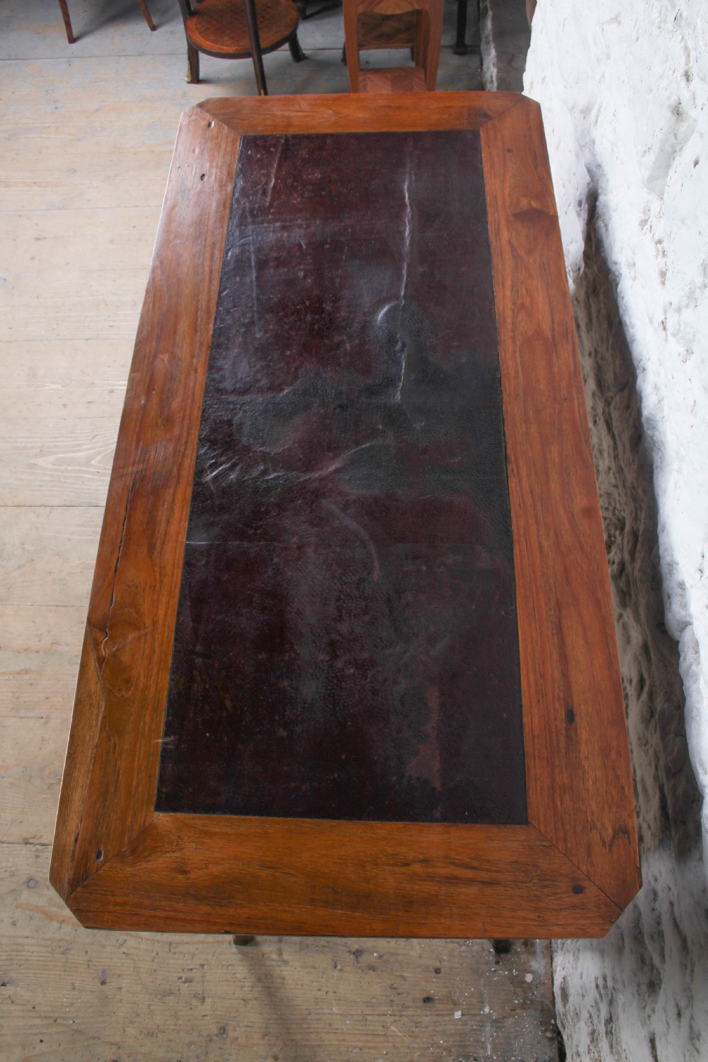 An antique warm brown wooden writing table featuring geometric parquetry inlay on two drawers, slender cabriole legs, and a central brass escutcheon keyhole. View III