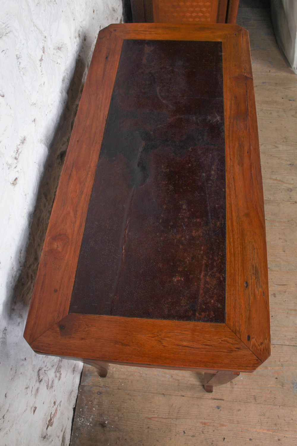 An antique warm brown wooden writing table featuring geometric parquetry inlay on two drawers, slender cabriole legs, and a central brass escutcheon keyhole. View IV