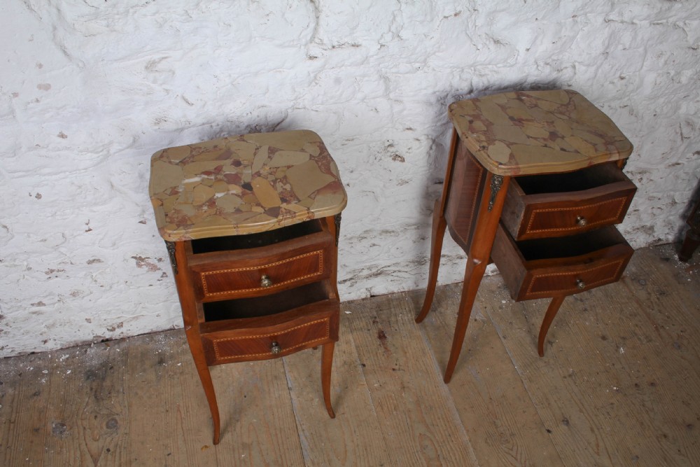 A pair of slender French wooden bedside tables featuring variegated marble tops, two inlaid drawers, and high cabriole legs. View IV