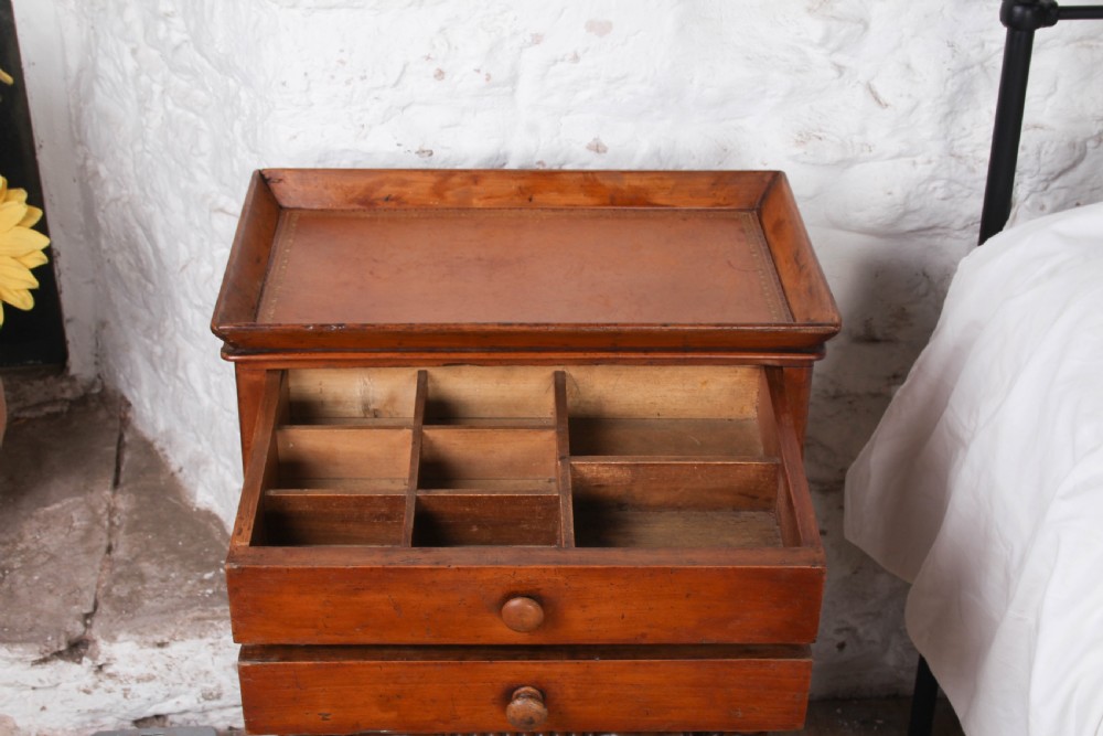 An antique warm brown wooden side table featuring bobbin-turned legs, a tray top, two drawers with round wooden knobs, and a turned stretcher. View III