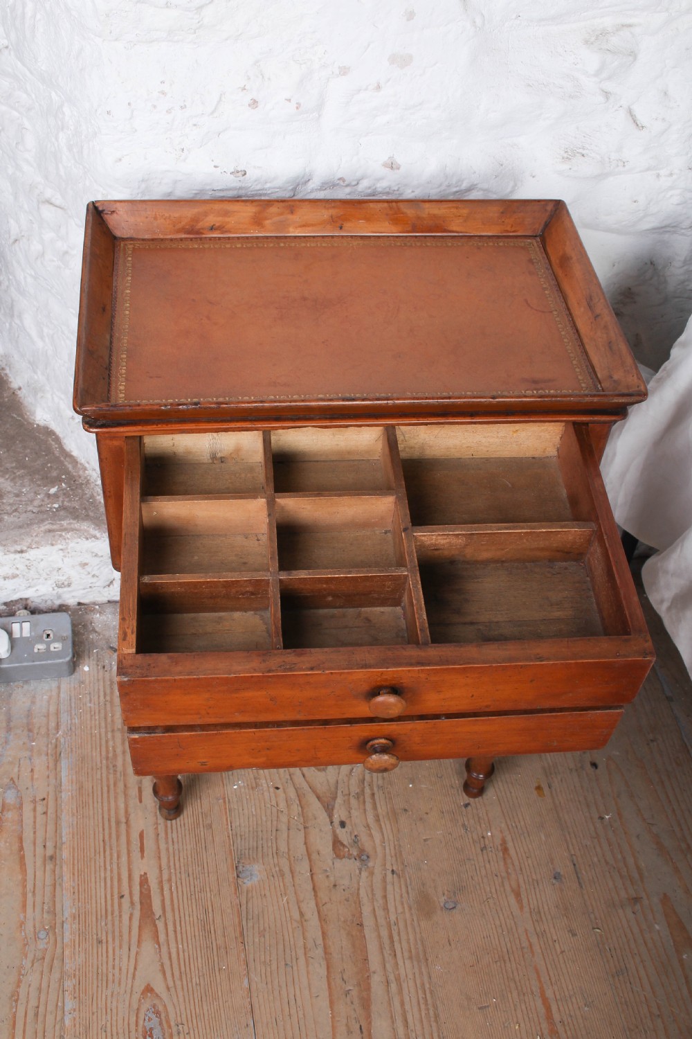 An antique warm brown wooden side table featuring bobbin-turned legs, a tray top, two drawers with round wooden knobs, and a turned stretcher. View IV
