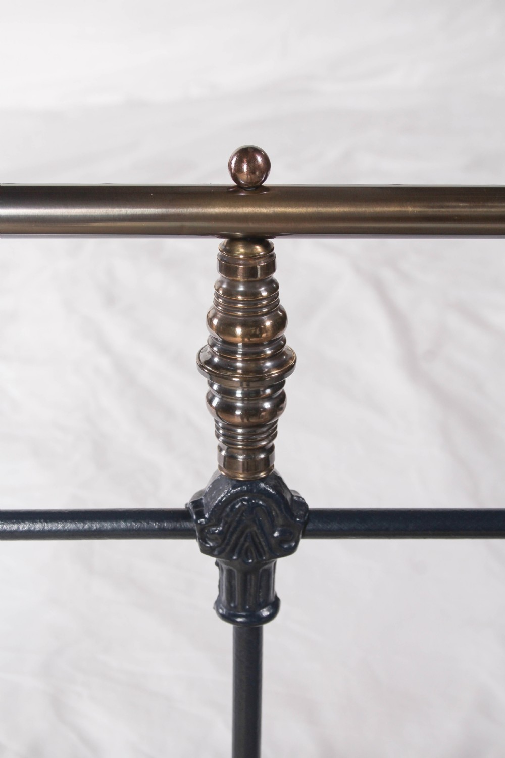 An Edwardian iron and brass double bedstead featuring dark vertical spindles, decorative cast collars, and polished brass top rails with brass finials. View III