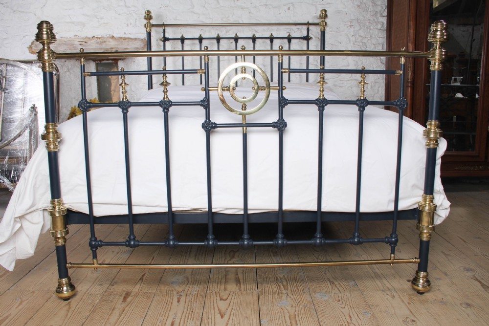 A Victorian king size bedstead crafted from black iron with polished brass rails, finials, and a central circular brass motif. View III