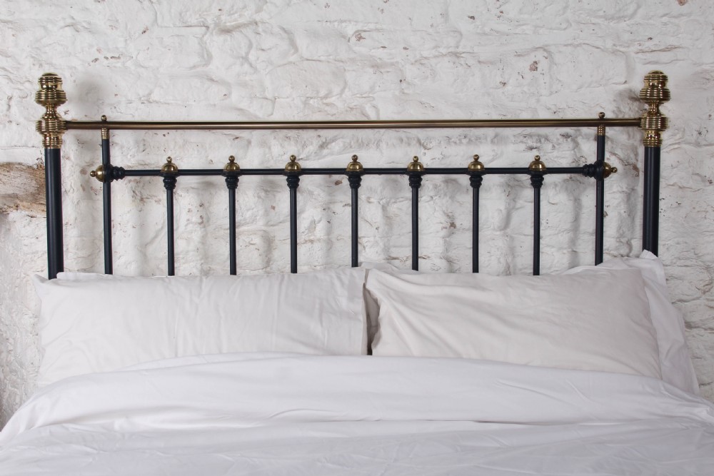 A Victorian king size bedstead crafted from black iron with polished brass rails, finials, and a central circular brass motif. View IV